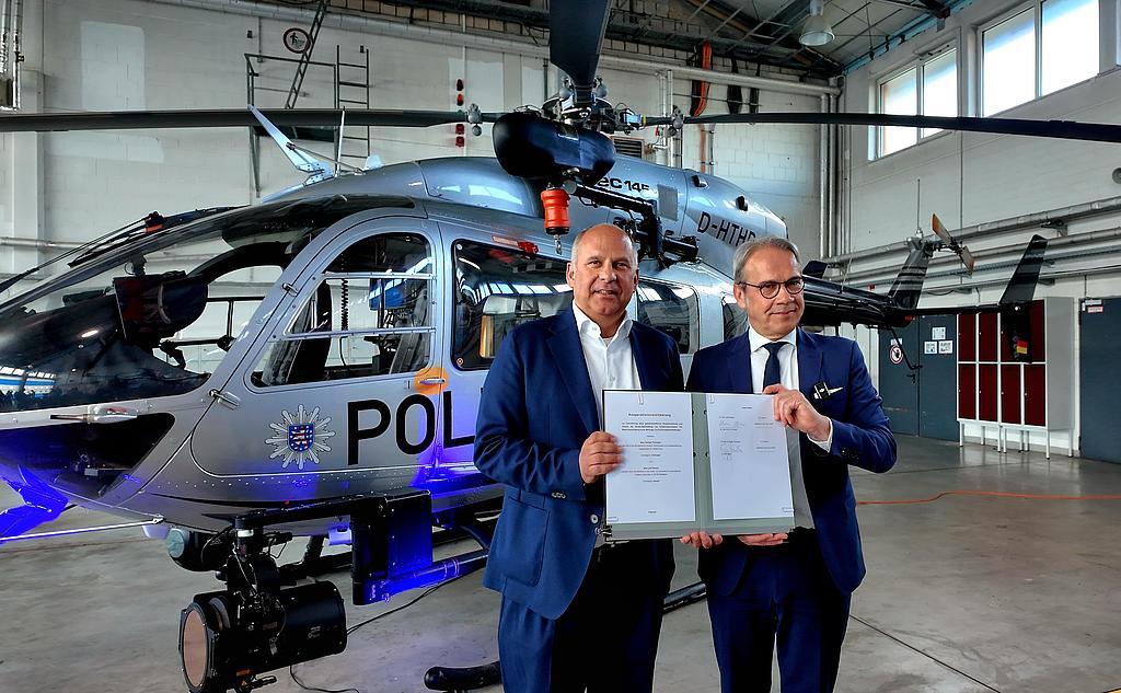 Innenminister Maier und Innenminister Posek mit der Vereinbarung vor einem Hubschrauber